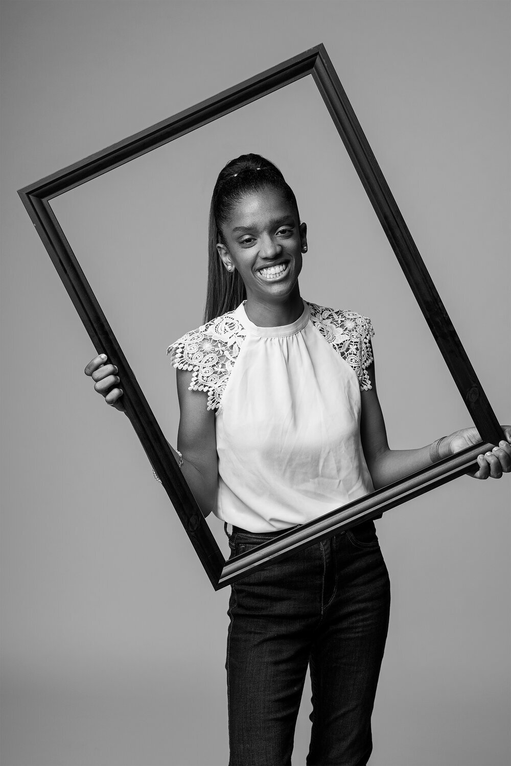 Janelle Hinds smiling while holding a frame